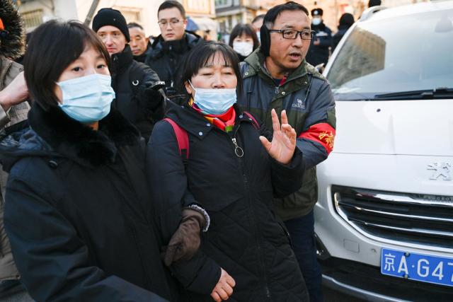 (FILES) People are seen outside the court that began hearing compensation cases filed by the relatives of passengers of the missing Malaysia Airlines flight MH370, in Beijing on November 27, 2023. A Beijing court ordered Malaysia Airlines on December 8, 2025 to pay compensation to the families of eight passengers from flight MH370, more than a decade after the plane disappeared. (Photo by Pedro PARDO / AFP)