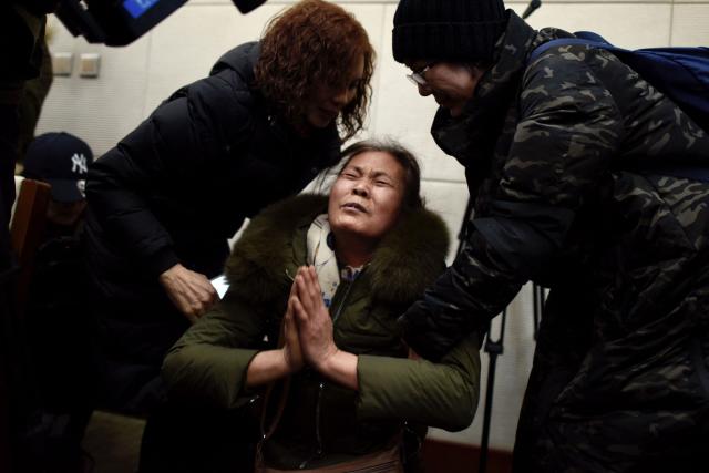 (FILES) A relative of missing Chinese passengers aboard Malaysia Airlines Flight 370 that disappeared on March 8, 2014 cries before a meeting in Beijing on January 18, 2017, a day after authorities announced the suspension of search operations for the aircraft. A Beijing court ordered Malaysia Airlines on December 8, 2025 to pay compensation to the families of eight passengers from flight MH370, more than a decade after the plane disappeared. (Photo by Fred DUFOUR / AFP)