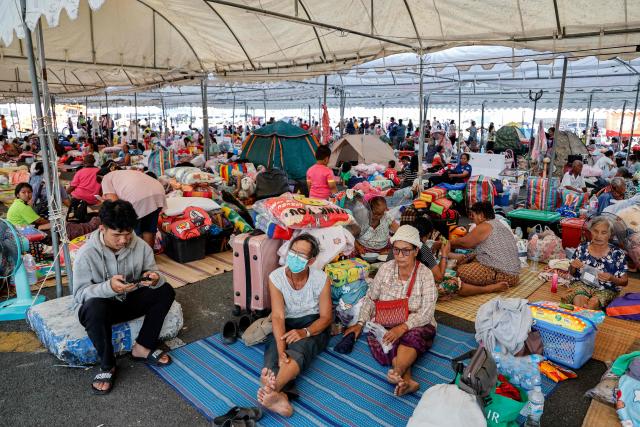 Evacuated Thai residents gather at a temporary shelter following clashes along the Thailand-Cambodia border in Buriram province on December 8, 2025. Thailand launched air strikes on its neighbour Cambodia on December 8, the Thai army said, with both sides trading blame for the latest eruption of fighting on their disputed border which killed a Thai soldier. (Photo by Sarot Meksophawannakul / THAI NEWS PIX / AFP)
