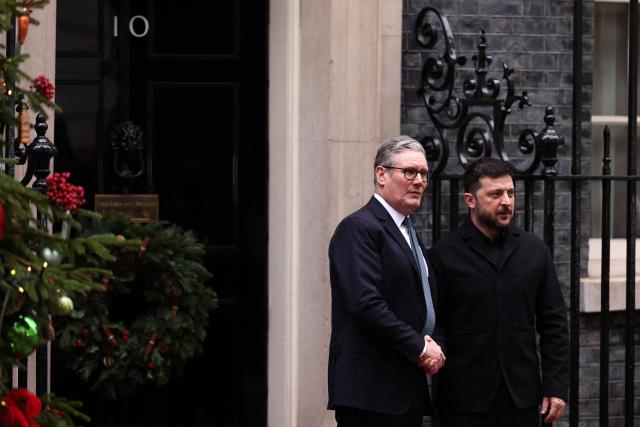 Ukraine's President Volodymyr Zelensky (R) is greeted by Britain's Prime Minister Keir Starmer (L) outside 10 Downing Street in central London on December 8, 2025, ahead of a meeting with leaders of Germany and France. (Photo by Adrian Dennis / POOL / AFP)