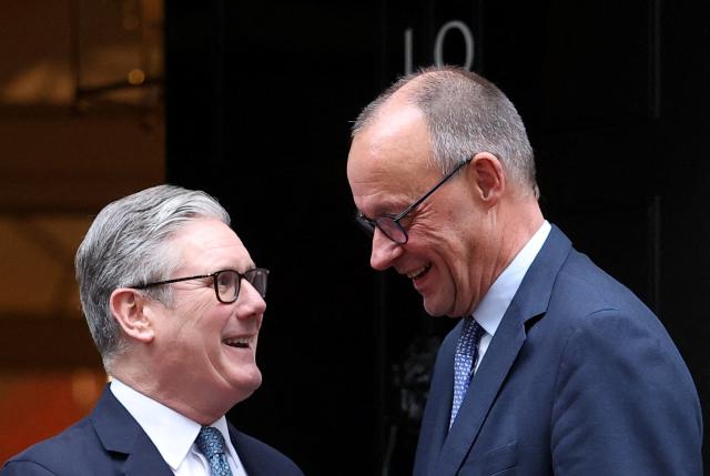 Britain's Prime Minister Keir Starmer (L) welcomes Germany's Chancellor Friedrich Merz (R) upon his arrival at Number 10 Downing Street in central London on December 8, 2025, as the leaders of Britain, France, Germany and Ukraine meet for talks. (Photo by Toby Melville / POOL / AFP)