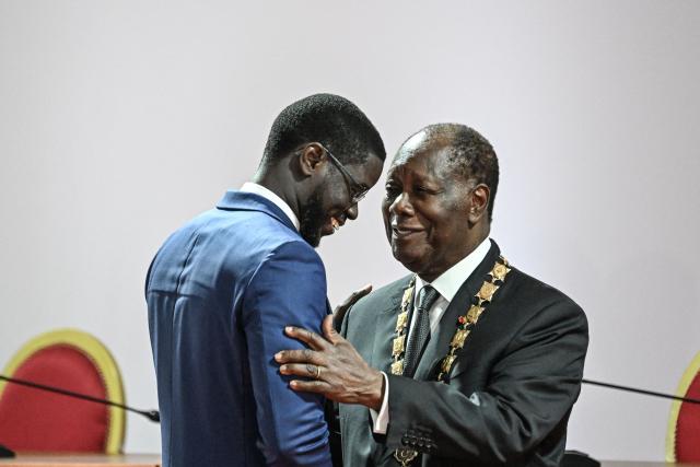 Ivory Coast President Alassane Ouattara (R) is congratulated by Senegal’s President Bassirou Diomaye Faye (L) at the Presidential Palace in Abidjan on December 8, 2025. (Photo by SIA KAMBOU / POOL / AFP)