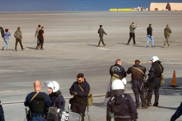 Farmers walk on the tarmac at Heraklion International Airport during a demonstration in Heraklion, on the island of Crete, on December 8, 2025. Farmers on Crete on Monday clashed with riot police near the Greek island's international airports in a burgeoning protest wave related to an EU subsidy probe. (Photo by Costas METAXAKIS / AFP)
