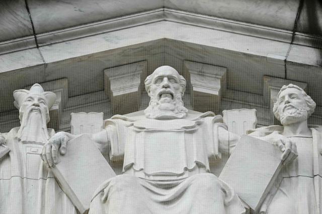 Engravings of, L/R, Confucius, Moses, and Solon are seen on the rear side US Supreme Court as the Court hears arguments in the case over President Donald Trump's dismissal of Federal Trade Commission (FTC) commissioner Rebecca Slaughter last March in Washington, DC, on December 8, 2025. The case is being closely watched due to its broader implications concerning President Trump's powers to fire the heads of independent government agencies. (Photo by Jim WATSON / AFP)