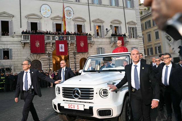 Pope Leo XIV stands on the popemobile surrounded by bodyguards as he leaves after paying homage to the Immaculate Conception, near the Spanish steps in Rome, on December 8, 2025. (Photo by Alberto PIZZOLI / AFP)