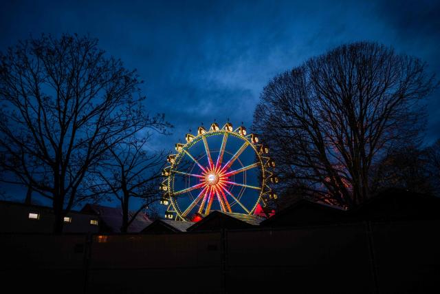 An illuminated ferris wheel is seen at a traditional Christmas market in front of the town hall in Berlin, Germany, on December 8, 2025. (Photo by John MACDOUGALL / AFP)