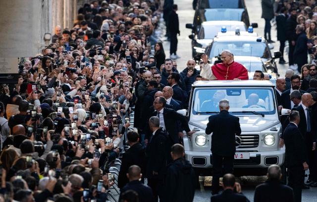 Pope Leo XIV waves to the crowd from the popemobile in Via dei Condotti as he arrives to pay homage to the Immaculate Conception, near the Spanish steps in Rome, on December 8, 2025. (Photo by Tiziana FABI / AFP)