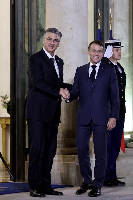 France's President Emmanuel Macron (R) welcomes Croatia's Prime Minister Andrej Plenkovic prior to a meeting at the Elysee Palace in Paris, on December 8, 2025. (Photo by Anne-Christine POUJOULAT / AFP)
