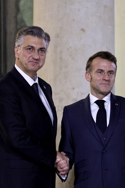 France's President Emmanuel Macron (R) welcomes Croatia's Prime Minister Andrej Plenkovic prior to a meeting at the Elysee Palace in Paris, on December 8, 2025. (Photo by Anne-Christine POUJOULAT / AFP)