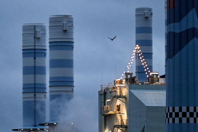 A bird flies over an industrial area of chemical plants in Frankfurt am Main, western Germany, on December 8, 2025. (Photo by Kirill KUDRYAVTSEV / AFP)