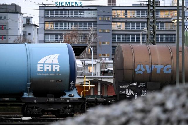 Railway tank cars with the logos of ERR European Rail Rent (L) and VTG Rail Logistics France (R) are pictured in front of an industrial area with chemical enterprises in Frankfurt am Main, western Germany, on December 8, 2025. (Photo by Kirill KUDRYAVTSEV / AFP)