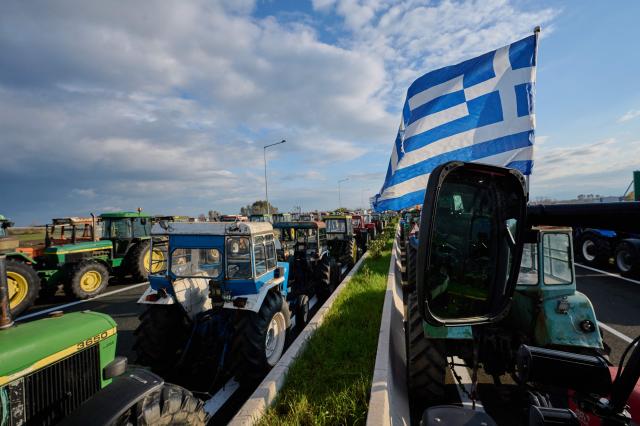 Farmers block the national highway with their tractors outside the central Greek city of Karditsa on December 8, 2025 to demand swifter access to EU subsidies. Greek farmers demanding the payment of EU subsidies on December 8 shut down the two main international airports on the island of Crete after clashing with riot police in a growing showdown with the government. (Photo by Aggelos NAKKAS / AFP)