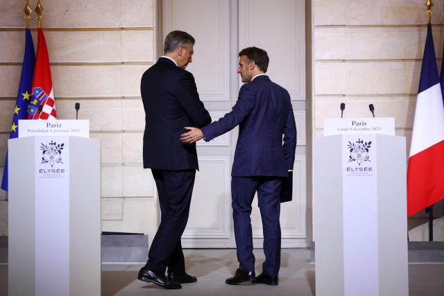 French President Emmanuel Macron (R) and Croatia's Prime Minister Andrej Plenkovic leave at the end of a press conference following their meeting with Croatia's Prime Minister at the Elysee Palace in Paris, on December 8, 2025. (Photo by Gonzalo Fuentes / POOL / AFP)