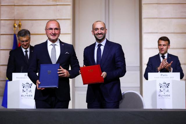 French Minister of Europe Benjamin Haddad (C,R) and Croatia's Minister of Foreign and European Affairs Gordan Grlic-Radman (C,L) pose during the signing ceremony of the new Franco-Croatian bilateral action plan, as French President Emmanuel Macron (R) and Croatia's Prime Minister Andrej Plenkovic look onat the Elysee Palace in Paris, on December 8, 2025. (Photo by Gonzalo Fuentes / POOL / AFP)