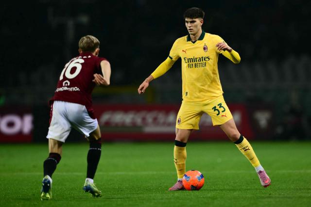 AC Milan's Italian defender #33 Davide Bartesaghi fights for the ball with Torino's Norwegian defender #16 Marcus Holmgren Pedersen during the Italian Serie A football match between Torino and AC Milan at the Allianz stadium in Turin, on December 8, 2025. (Photo by Marco BERTORELLO / AFP)