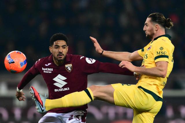 AC Milan's French midfielder  #12 Adrien Rabiot kicks the ball in front of Torino's Equatorial Guinea defender #23 Saul Basilio Coco-Bassey Oubina during the Italian Serie A football match between Torino and AC Milan at the Allianz stadium in Turin, on December 8, 2025. (Photo by Marco BERTORELLO / AFP)