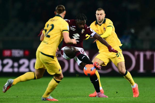 Torino's Colombian forward #91 Duvan Zapata fights for the ball with AC Milan's French midfielder  #12 Adrien Rabiot and AC Milan's Serbian defender #31 Strahinja Pavlovic during the Italian Serie A football match between Torino and AC Milan at the Allianz stadium in Turin, on December 8, 2025. (Photo by Marco BERTORELLO / AFP)