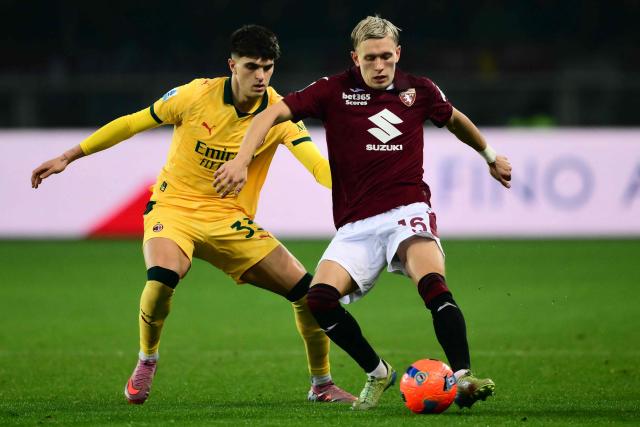 AC Milan's Italian defender #33 Davide Bartesaghi fights for the ball with Torino's Norwegian defender #16 Marcus Holmgren Pedersen during the Italian Serie A football match between Torino and AC Milan at the Allianz stadium in Turin, on December 8, 2025. (Photo by Marco BERTORELLO / AFP)