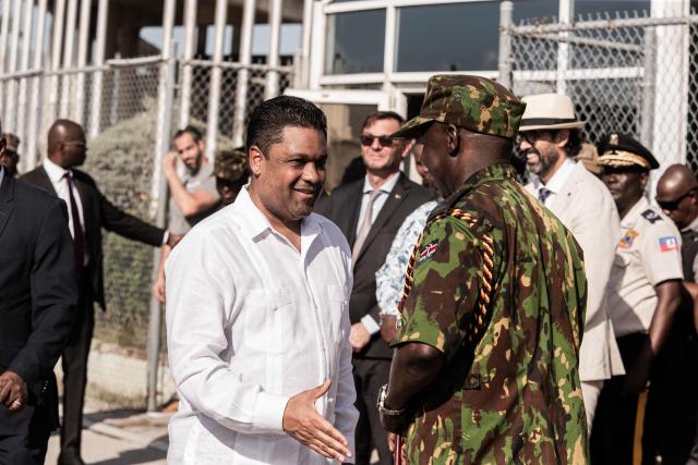 President of Haiti’s Transitional Presidential Council, Laurent Saint-Cyr welcomes  a group of Kenyan police officers at Toussaint Louverture International Airport in Port-au-Prince, Haiti, on December 8, 2025. Kenya announced on December 8th that it had deployed more than 230 highly specialized police officers. They arrive at a critical moment, following the expansion of the Gang Suppression Force's (GSF) mandate published on October 3, 2025. (Photo by Clarens SIFFROY / AFP)