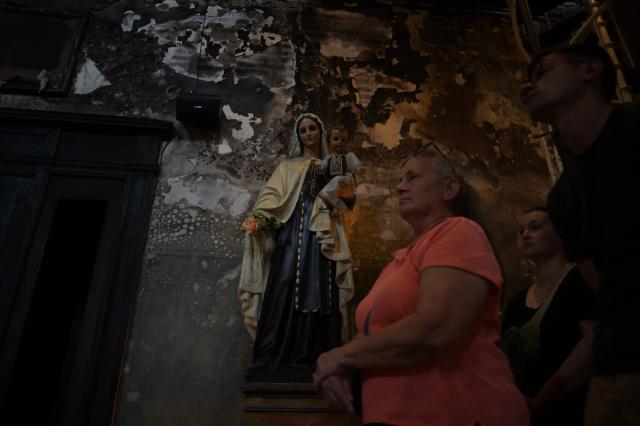 A woman visits the Iglesia de la Veracruz (church of Vera Cruz) at Lastarria neigborhood, severely damaged by fire and vandalism during Chile's 2019 "Estallido Social" (Social Outburst) protests, in Santiago on December 8, 2025. Chile will choose its next president in a runoff on December 14, 2025, with far-right candidate Jose Antonio Kast as the clear favorite against leftist Jeannette Jara, after a campaign marked by fears over crime and irregular migrants. (Photo by Eitan ABRAMOVICH / AFP)