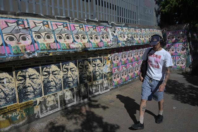 A pedestrian walks past posters supporting Chilean presidential candidate Jeannette Jara of the Unidad por Chile coalition in Santiago on December 8, 2025. Chile will choose its next president in a runoff on December 14, 2025, with far-right candidate Jose Antonio Kast as the clear favorite against leftist Jeannette Jara, after a campaign marked by fears over crime and irregular migrants. (Photo by Eitan ABRAMOVICH / AFP)
