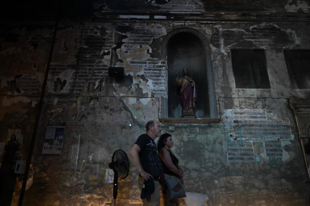 People visit the Iglesia de la Veracruz (church of Vera Cruz) at Lastarria neigborhood, severely damaged by fire and vandalism during Chile's 2019 "Estallido Social" (Social Outburst) protests, in Santiago on December 8, 2025. Chile will choose its next president in a runoff on December 14, 2025, with far-right candidate Jose Antonio Kast as the clear favorite against leftist Jeannette Jara, after a campaign marked by fears over crime and irregular migrants. (Photo by Eitan ABRAMOVICH / AFP)