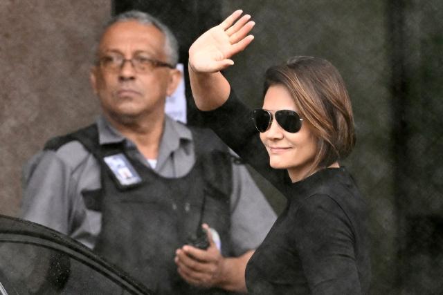 (FILES) Michelle Bolsonaro, wife of former Brazil's President (2019–2023) Jair Bolsonaro waves at supporters on arrival at the Federal Police headquarters, where Bolsonaro is being held, in Brasilia, on November 23, 2025. Michelle Bolsonaro, suspended her participation in a party event for health reasons, her team reported on Monday, weeks after her husband was imprisoned for staging a coup. (Photo by Evaristo Sa / AFP)