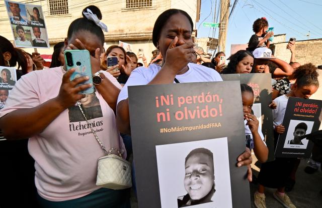 Women cry as they hold the picture of one of the four minors apprehended by soldiers and found dead near a military base, during a rally to demand justice a year after their apprehension in Guayaquil, Ecuador on December 8, 2025. (Photo by MARCOS PIN / AFP)