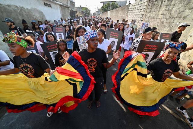 Relatives of the four minors apprehended by soldiers and found dead near a military base, dance during a rally to demand justice a year after their apprehension in Guayaquil, Ecuador on December 8, 2025. (Photo by MARCOS PIN / AFP)