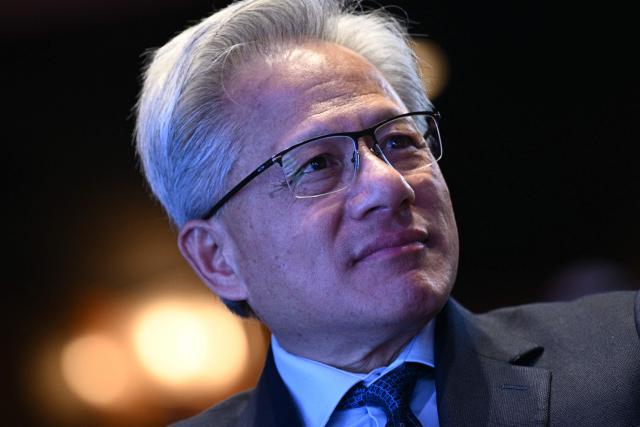 (FILES) Nvidia founder and CEO Jensen Huang looks on as US President Donald Trump speaks at the US-Saudi Investment Forum at the John F. Kennedy Center for the Performing Arts in Washington, DC on November 19, 2025. President Donald Trump said on December 8, 2025 that he had reached an agreement with President Xi Jinping to allow US chip giant Nvidia to export advanced artificial intelligence chips to China. (Photo by Brendan SMIALOWSKI / AFP)