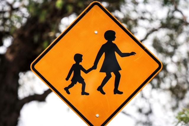 (FILES) A safety sign is seen outside a primary school in Sydney on October 8, 2025. Australia will ban young teenagers from social media on December 10, 2025, launching a world-first crackdown designed to unglue children from addictive scrolling on the likes of Facebook, Instagram and TikTok. (Photo by DAVID GRAY / AFP)