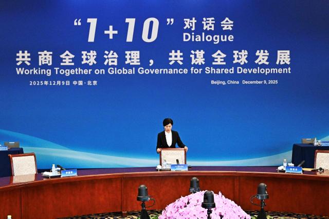 An attendee prepares for the 1+10 Dialogue with leaders of International Economic Organisations, with China’s Premier Li Qiang in Beijing on December 9, 2025. (Photo by Pedro PARDO and Pedro Pardo / POOL / AFP)