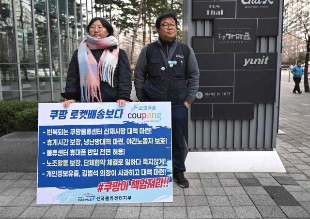 Transportation union members hold a placard showing the logo of South Korean online delivery service Coupang, during a protest to demand workers' rights outside a building housing the headquarters of Coupang in Seoul on December 9, 2025. South Korean police raided the Seoul headquarters of e-commerce giant Coupang on December 9, over a recent data leak believed to have affected almost two-thirds of the country's population. (Photo by Jung Yeon-je / AFP)