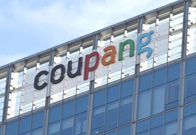 A general view shows the logo of South Korean online delivery service Coupang, at a building housing the company's headquarters in Seoul on December 9, 2025. South Korean police raided the Seoul headquarters of e-commerce giant Coupang on December 9, over a recent data leak believed to have affected almost two-thirds of the country's population. (Photo by Jung Yeon-je / AFP)