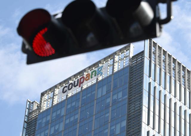 A general view shows the logo of South Korean online delivery service Coupang, at a building housing the company's headquarters in Seoul on December 9, 2025. South Korean police raided the Seoul headquarters of e-commerce giant Coupang on December 9, over a recent data leak believed to have affected almost two-thirds of the country's population. (Photo by Jung Yeon-je / AFP)