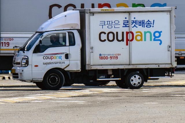 A worker drives a delivery truck of South Korean e-commerce giant Coupang in Seoul on December 9, 2025. South Korean police raided the Seoul headquarters of e-commerce giant Coupang on December 9, over a recent data leak believed to have affected almost two-thirds of the country's population. (Photo by ANTHONY WALLACE / AFP)