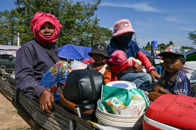 Residents gather outside a temple after they evacuated following clashes along the Cambodia-Thailand border, in Siem Reap province on December 9, 2025. Two more Thai soldiers were killed on December 9, in renewed border clashes with neighbour Cambodia, the Thai army said, raising the death toll for Thai troops to three. (Photo by TANG CHHIN SOTHY / AFP)