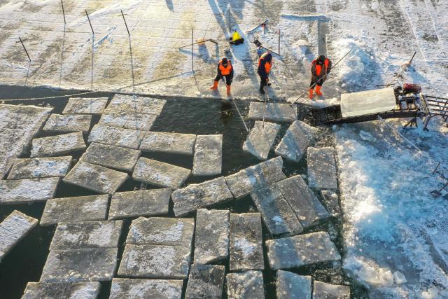 Workers harvest ice from the frozen Songhua River in preparation for the annual Harbin Ice and Snow World Festival in Harbin, China’s northeast Heilongjiang province on December 8, 2025. (Photo by AFP) / China OUT