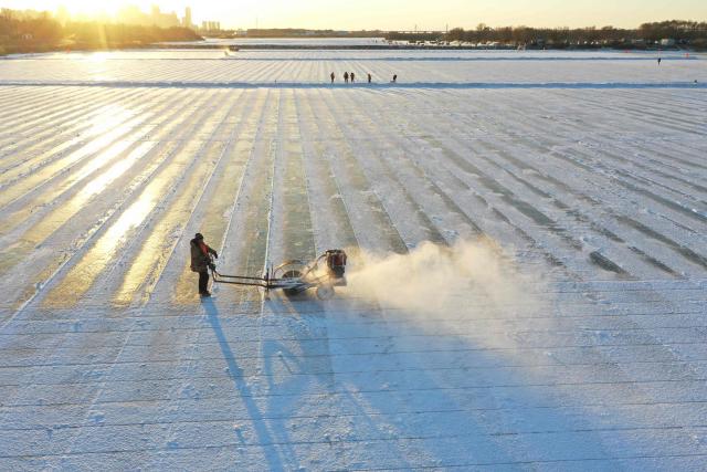 Workers harvest ice from the frozen Songhua River in preparation for the annual Harbin Ice and Snow World Festival in Harbin, China’s northeast Heilongjiang province on December 8, 2025. (Photo by AFP) / China OUT