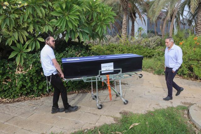 A member of a repatriation company prepares the coffin of a Thai national Sudthisak Rinthalak, who was kidnapped by Hamas militants from orchards near Kibbutz Be’eri on October 7, 2023, during a ceremony after his body was returned to Israel at Ben-Gurion Airport on December 9, 2025. (Photo by GIL COHEN-MAGEN / AFP)