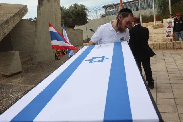 A member of a repatriation company prepares the coffin of a Thai national Sudthisak Rinthalak, who was kidnapped by Hamas militants from orchards near Kibbutz Be’eri on October 7, 2023, during a ceremony after his body was returned to Israel at Ben-Gurion Airport on December 9, 2025. (Photo by GIL COHEN-MAGEN / AFP)
