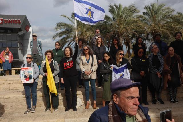People stand near the coffin of a Thai national Sudthisak Rinthalak, who was kidnapped by Hamas militants from orchards near Kibbutz Be’eri on October 7, 2023, during a ceremony after his body was returned to Israel at Ben-Gurion Airport on December 9, 2025. (Photo by GIL COHEN-MAGEN / AFP)