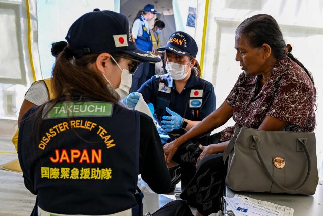 Japan Disaster Relief (JDR) medical officers tend to flood victims at a camp in Chilaw on December 9, 2025. (Photo by Ishara S. KODIKARA / AFP)
