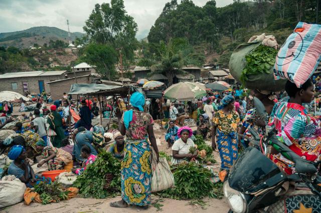 Vendors and customers crowd a market in Uvira on December 9, 2025. Intense fighting is taking place on Tuesday in the eastern Democratic Republic of Congo (DRC), with the M23 group, supported by the Rwandan army, continuing its rapid advance towards Uvira, a strategic Congolese city located near the border with neighboring Burundi and now under threat. The anti-government armed group and the Rwandan soldiers—estimated at 6,000 to 7,000 on Congolese soil according to UN experts—were reportedly only about fifteen kilometers north of the city, home to several hundred thousand inhabitants, as of Tuesday morning, according to security and military sources cited by AFP. (Photo by AFP)