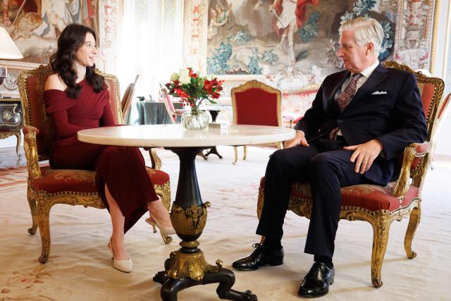 Former Olympic gold medalist gymnast Nina Derwael (L) speaks with King Philippe - Filip of Belgium before receiving the insignia of Grand Officer of the Order of Leopold during a ceremony at the Royal Castle in Laeken, on the outskirts of Brussels, on December 9, 2025. (Photo by BENOIT DOPPAGNE / Belga / AFP) / Belgium OUT