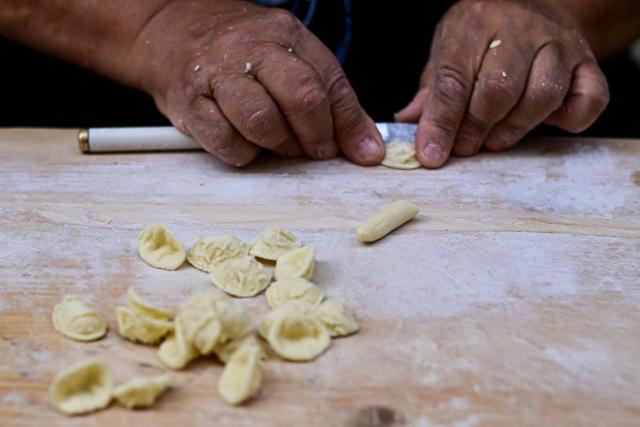 (FILES) Nunzia, prepares traditional orecchiette pasta in the street at Bari Vecchia, Apulia, on June 11, 2024. Italy is waiting for the final decision of Unesco, on December 10, 2025, regarding the recognition of Italian cuisine as an "Intangible Cultural Heritage of Humanity". (Photo by Piero CRUCIATTI / AFP)