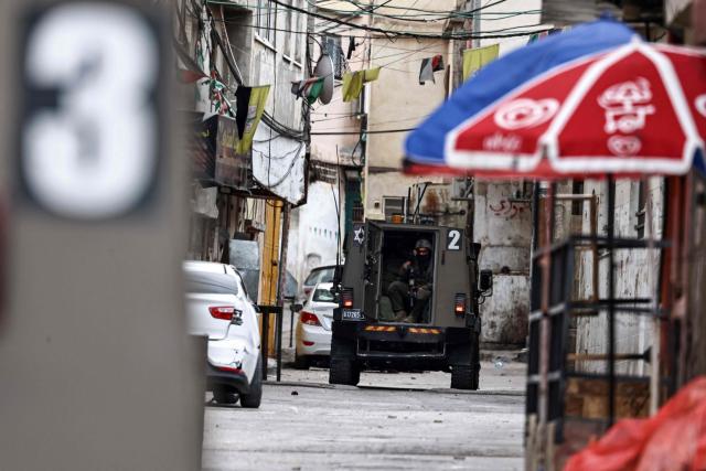 An Israeli army soldier sits inside an armoured vehicle during a military raid at Al-Amari refugee camp near the city of Ramallah in the Israeli-occupied West Bank on December 9, 2025. Violence in the West Bank, which Israel has occupied since 1967, has soared since the Hamas attack on Israel triggered the Gaza war in October 2023. At least 1,006 Palestinians, including militants, have been killed in the West Bank by Israeli forces or settlers since then, according to the Palestinian health ministry. During the same period, 43 Israelis, including soldiers, have been killed in Palestinian attacks in the West Bank, according to official Israeli figures. (Photo by Zain JAAFAR / AFP)