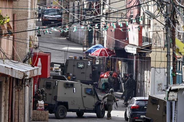 Israeli army soldiers take position during a military raid in Al-Amari refugee camp near the city of Ramallah in the Israeli-occupied West Bank on December 9, 2025. Violence in the West Bank, which Israel has occupied since 1967, has soared since the Hamas attack on Israel triggered the Gaza war in October 2023. At least 1,006 Palestinians, including militants, have been killed in the West Bank by Israeli forces or settlers since then, according to the Palestinian health ministry. During the same period, 43 Israelis, including soldiers, have been killed in Palestinian attacks in the West Bank, according to official Israeli figures. (Photo by Zain JAAFAR / AFP)