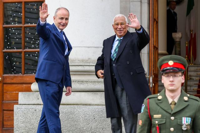 Ireland's Prime Minister Micheal Martin (L) and European Council President António Costa (C) wave as they meet during the latter's visit to Dublin on December 9, 2025. (Photo by Paul Faith / AFP)