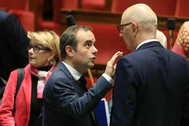 France's Prime Minister Sebastien Lecornu talks to Finance Minister Roland Lescure during a session of questions to the government at the National Assembly, France's lower house parliament, in Paris on December 9, 2025. (Photo by Alain JOCARD / AFP)